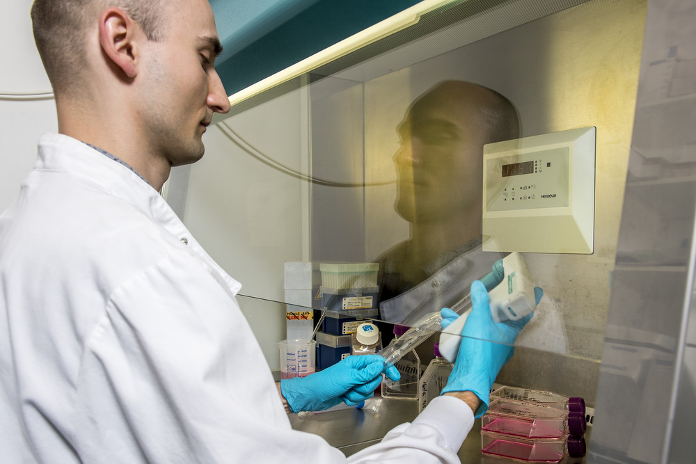 Researcher using a pipette in a fume hood